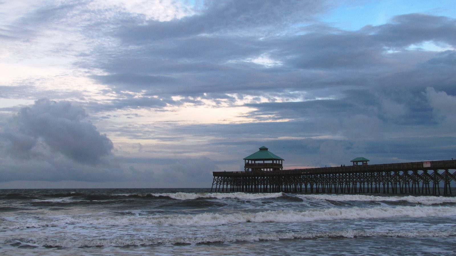 The fishing pier and wide sandy shoreline at Folly Beach, South Carolina